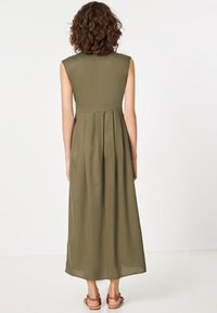 Ärmlös midiklänning i olivgrönt, med en figursydd bodice och en veckad kjol. Lättviktig tyg med en slät textur.