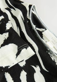 Černobíle pruhované tričko vyrobené z měkké bavlny s kulatým výstřihem a krátkými rukávy. Obsahuje štítek na vnitřním švu.