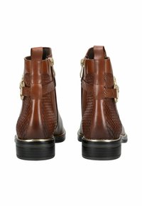 Botas de tobillo de cuero marrón con detalles de patrón de serpiente texturizado, acentos dorados, cremalleras laterales y suelas negras contrastantes.