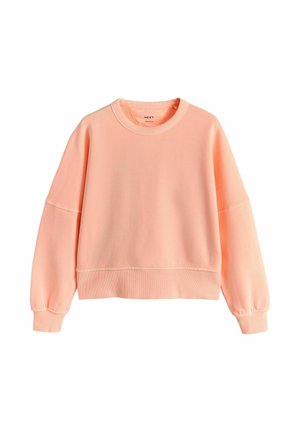 Soft peach-colored crewneck sweatshirt with long sleeves and ribbed cuffs and waistband, laid flat on a white background.