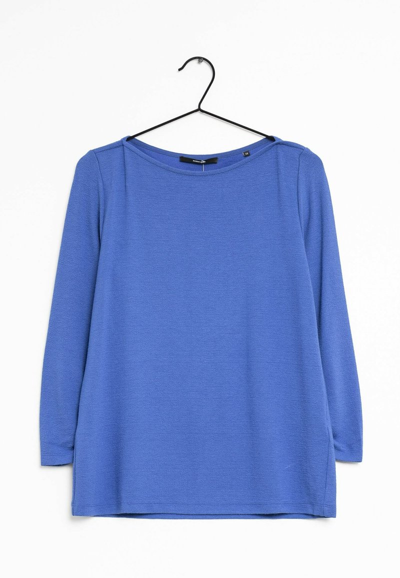 Blå langærmet bluse med rund halsudskæring, side-slids, lavet af tekstureret stof. Den hænger på en sort bøjle mod en hvid baggrund.