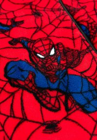 Tessuto in pile rosso con design di Spider-Man. L'illustrazione comprende Spider-Man con dettagli blu e neri su uno sfondo di ragnatela.