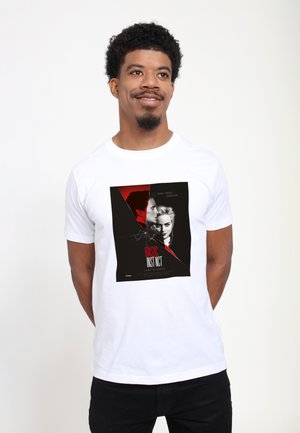 Hvid bomulds t-shirt med trykt grafik af en filmaffiche med røde og sorte designelementer, som viser titlen "BASIC INSTINCT."