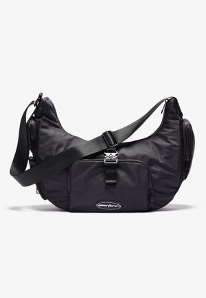 Sac bandoulière noir en forme de croissant avec poche avant à boucle, sangle réglable, compartiments latéraux zippés et design supérieur incurvé.