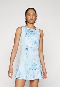Világoskék sportruha, textúrált mintával kék és pasztell rózsaszín árnyalataiban. Illeszkedő felsőrész és fodros szoknyával rendelkezik.