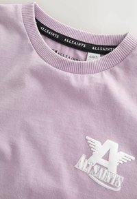 Lilla crewneck-trøje med ribbet krave og hvidt AllSaints-logo med stiliserede vinger på brystet.