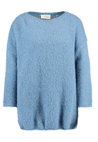 Ljusblå oversized tröja av texturerat, mjukt och luddigt tyg. Den har rund halsringning och trekvartsärmar.