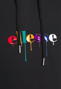 Sweat à capuche noir avec un logo "ellesse" multicolore agrémenté d'un effet goutte de peinture. Comprend des cordons noirs avec embouts métalliques.