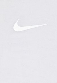 Logo de Nike Swoosh en blanco sobre un fondo gris claro y texturizado. El logo está centrado, con un diseño suave y curvo.