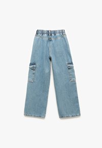 Lichtblauwe denim cargobroek met een elastische tailleband, wijde pijpen en twee zijvakjes. Kenmerkt zich door stikseldetails en onbewerkte zomen.