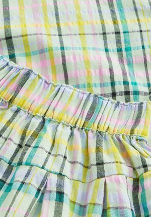 Leichtes, mehrfarbiges Karostoffmuster mit grünen, gelben, pinken und schwarzen Linien. Elastischer Bund mit gerafftem Saum.