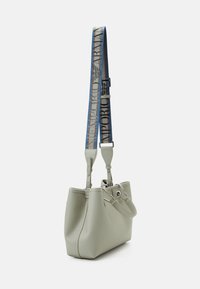 Vaaleanharmaa nahkainen olkalaukku, jossa on jämäkkä muoto, säädettävä sininen olkahihna, jossa teksti 'Emporio Armani', ja hopeanväriset metalliosat.