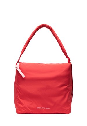Sac bandoulière rectangulaire rouge avec une poignée rembourrée, une tirette de fermeture éclair blanche et le texte « Herschel Supply Company » près du bas au centre.