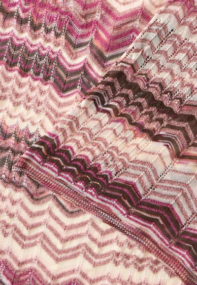 Tissu tricoté rose, marron et beige avec un motif en zigzag et diverses mailles texturées, plié pour montrer différentes sections du design.