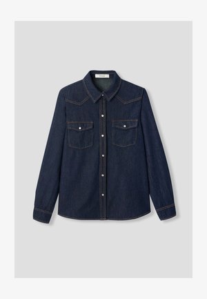 Chemise en denim bleu foncé avec un col pointu, deux poches poitrine et une fermeture à boutons-pression avec des détails de surpiqûres orange contrastantes.