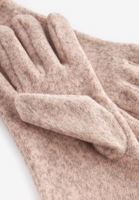 Gants en laine rose avec une finition douce et texturée. Caractéristiques : un ajustement parfait et un design légèrement rembourré pour plus de chaleur.