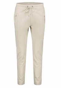 Beige joggingové kalhoty s elastickým pasem a stahovací šňůrkou. Obsahují dvě přední kapsy na zip a zúžené nohy pro těsný vzhled.