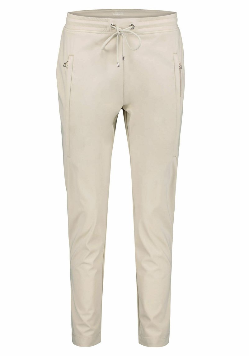 Beige joggingové kalhoty s elastickým pasem a stahovací šňůrkou. Obsahují dvě přední kapsy na zip a zúžené nohy pro těsný vzhled.