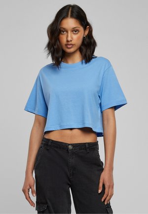 T-shirt court bleu clair en coton doux avec des manches courtes et un col rond, associé à un pantalon cargo noir avec des poches latérales.