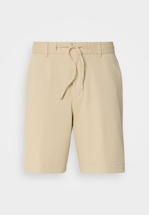 Pantalones cortos beige de tela texturizada, con cintura elástica y cordón ajustable, y bolsillos laterales para mayor funcionalidad.