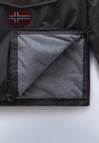 Veste noire avec doublure en polaire grise partiellement dézippée, montrant l'intérieur, avec un écusson du drapeau norvégien brodé sur la poitrine.
