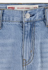 Short en jean Levi's bleu clair avec fermeture par boutons et étiquette visible "Relaxed Short" à l’intérieur de la ceinture.