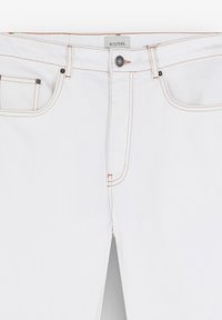 Jeans blancos de algodón con costuras naranjas, que presentan un botón frontal, cremallera y un diseño estándar de cinco bolsillos.