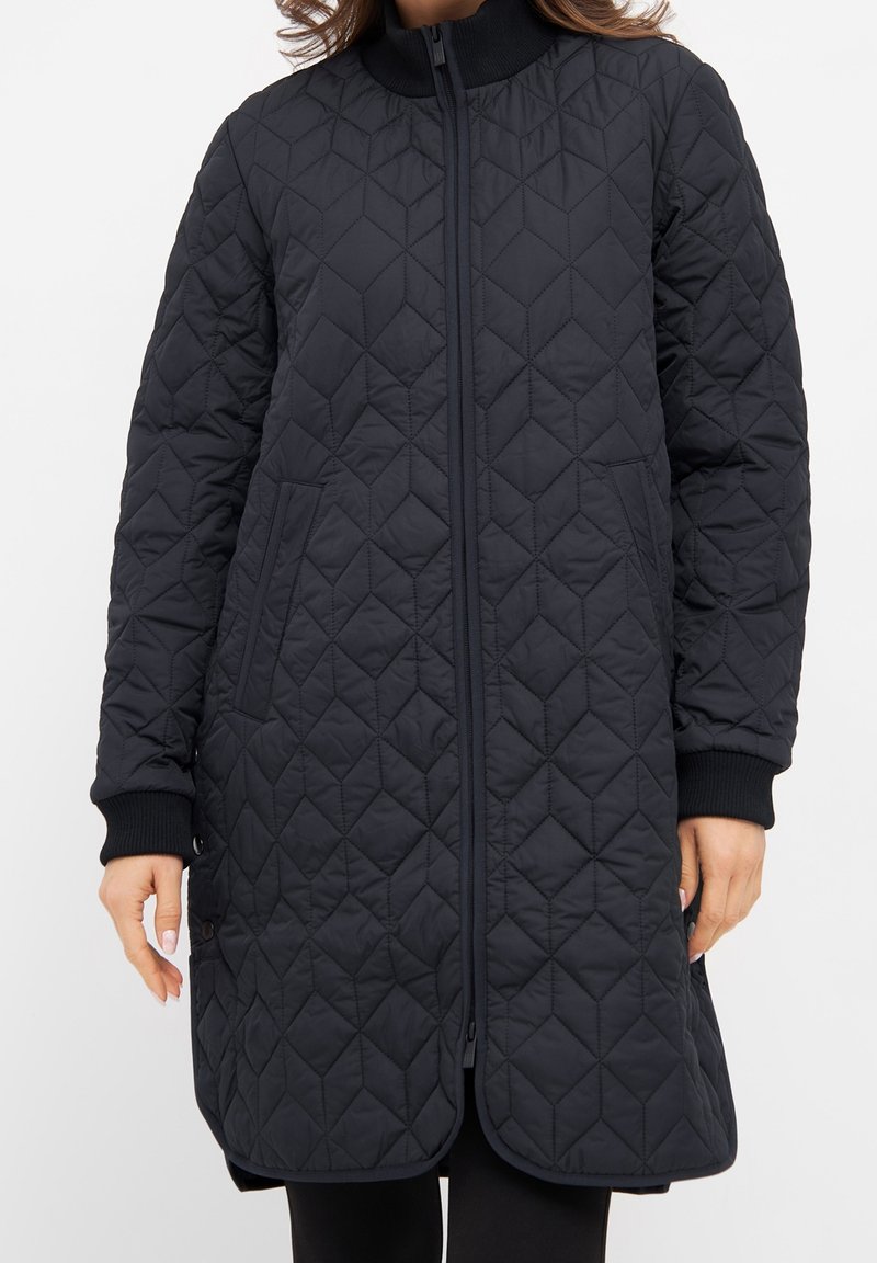 Prošívaná černá bunda s vysokým límcem, předním zipem a bočními kapsami. Obsahuje diamantový vzor a žebrované manžety pro zvýšení textury.