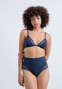 Bralette bleu marine avec des dentelles et lingerie taille haute en tissu doux. Comprend des bretelles réglables et de délicats accents en dentelle.
