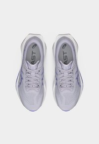 Ανοιχτό γκρι παπούτσια τρεξίματος με αεριζόμενο επάνω μέρος από δίχτυ με μοβ λεπτομέρειες, επενδεδυμένη γλώσσα και υφασμένο πάτο για πρόσφυση.