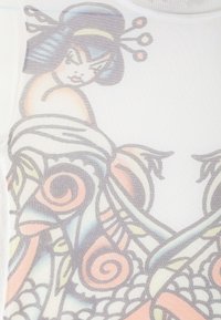 Top in tessuto trasparente caratterizzato da una stampa che raffigura una donna con capelli blu, intricate spirali e colori pastello su uno sfondo chiaro.