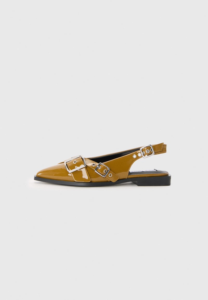 Pointed-toe slingback shoes in glossy mustard yellow patent leather, featuring two silver buckle accents, flat black sole, and open heel design.