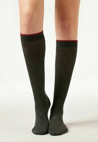 Kniestrümpfe in Dunkelgrau mit strukturierter Oberfläche, die kleine mehrfarbige Punkte und einen kontrastierenden roten Bund am oberen Ende aufweisen.
