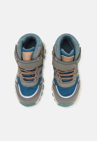 Baskets de sport grises et bleues avec une tige en maille, une semelle en caoutchouc, une sangle ajustable, un col rembourré et des détails de lacets contrastants.