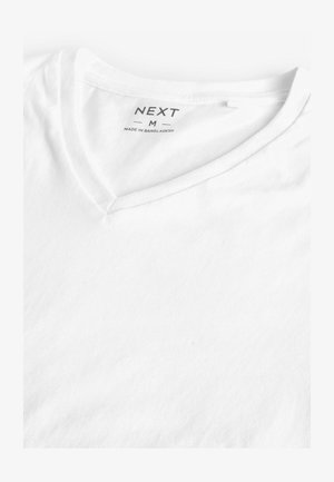 Hvid V-hals T-shirt i bomuldsmateriale. Har en blød tekstur, etiket trykt i sort med "NEXT" og størrelse "M." Enkel og minimalistisk design.