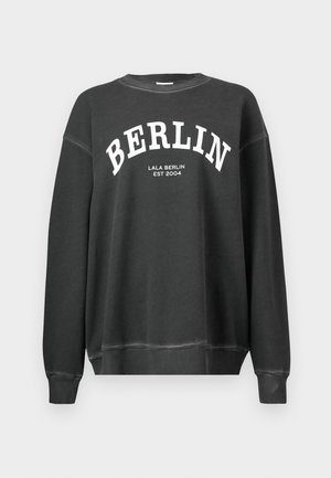 Tmavě šedá mikina s kulatým výstřihem. "BERLÍN" vytištěno velkými bílými písmeny na hrudi, s nápisem "LALA BERLÍN EST 2004" pod tím.