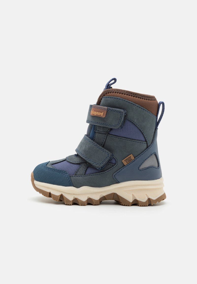 Bottes en mélange de matériaux bleu et marine avec des sangles Velcro, des accents marron et une semelle en caoutchouc texturée présentant un motif en zigzag.