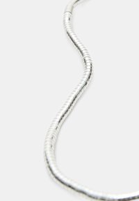 Collana metallica argentata realizzata con piccoli anelli circolari, caratterizzata da una forma flessibile e ondulata e da una superficie liscia e lucida.