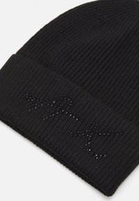 Berretto di maglia nera con texture a costine e orlo ripiegato, caratterizzato da un design decorativo composto da perline nere lucide.