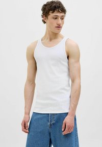 Top in cotone bianco a costine con scollatura rotonda e spalline larghe, abbinato a pantaloni corti in denim blu. Tessuto liscio e design aderente.
