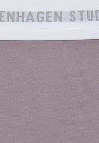 Light mauve fabric with a smooth, slightly textured surface. A white band with "Copenhagen Studios" in gray is at the top.