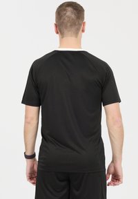 Musta lyhythihainen t-paita, jossa on pyöreä kaula-aukko ja urheilullinen istuvuus, valmistettu sileästä kankaasta. Takana on puhdas ilme ilman grafiikoita.