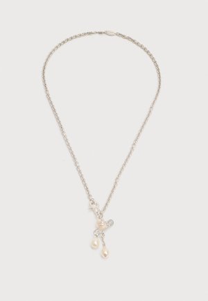 Silver chain necklace with three dangling small white pearl charms on a plain white background.