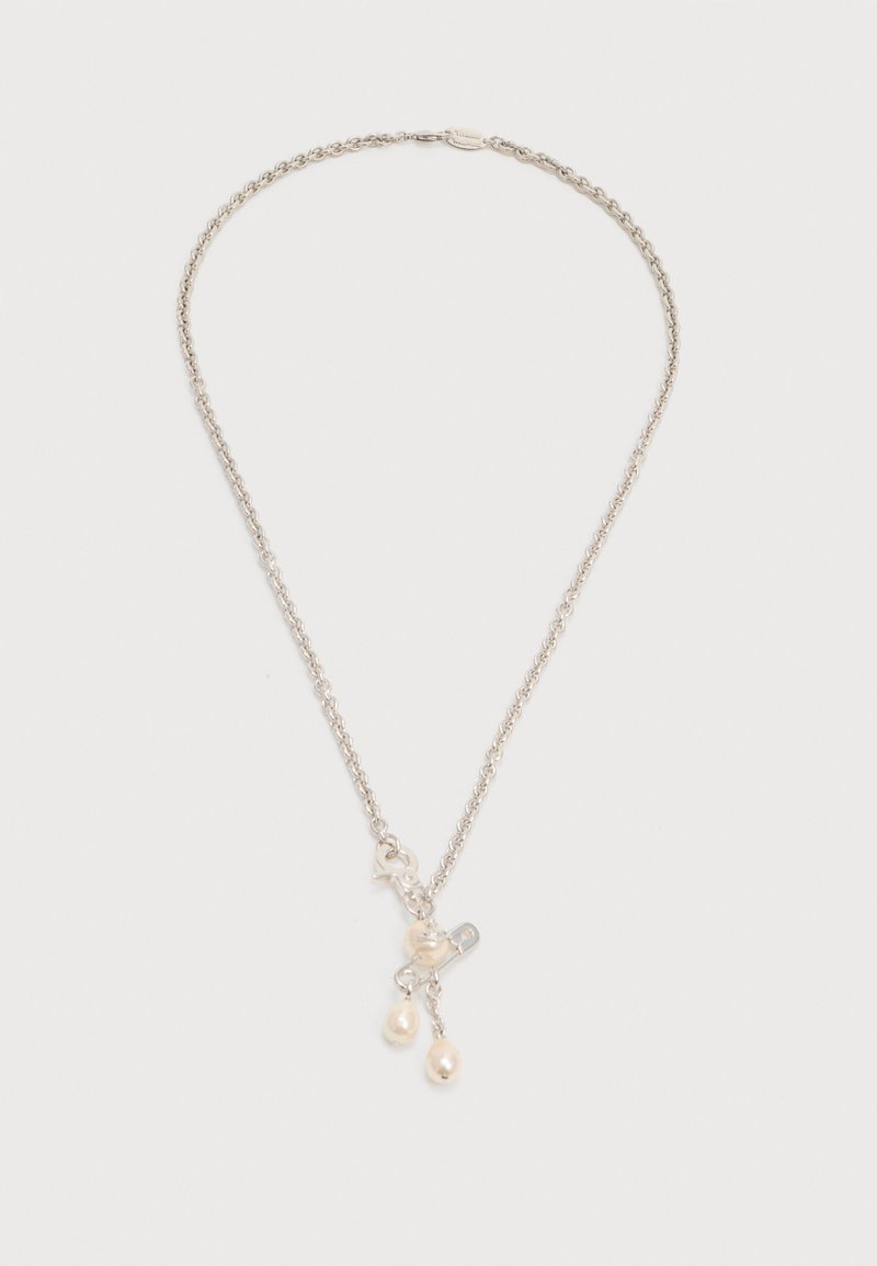 Silver chain necklace with three dangling small white pearl charms on a plain white background.