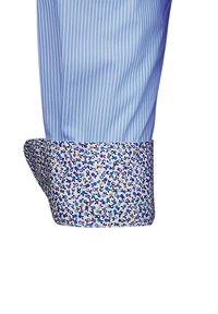 Camicia a righe azzurre con polsini a fantasia floreale in tonalità di viola, blu e beige, caratterizzata da una texture liscia.