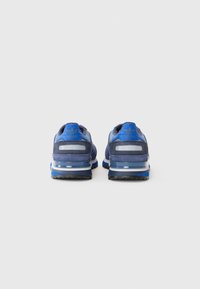 Blue suede sneakers with a mesh upper, reflective accents, and a cushioned sole. Notable branding on the heel and rubber outsole.