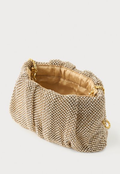 Μικρό χρυσό βραδινό τσαντάκι χειρός διακοσμημένο με λαμπερά στρας, ανοιχτό επάνω μέρος και επένδυση από μπεζ ύφασμα στο εσωτερικό.