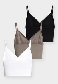 Τρία κομμένα ριμπ τοπ σε μαύρο, ταουπ και λευκό με λεπτούς ρυθμιζόμενους ιμάντες και ντεκολτέ σε σχήμα V, τοποθετημένα το ένα πάνω στο άλλο σε γκρι φόντο.