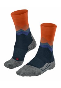 Calcetines de crew coloridos con un puño acanalado naranja, patrón de montaña en zigzag en tonos de naranja, azul y gris, y una suela acolchada gris.