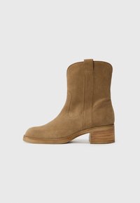 Stivaletto in pelle scamosciata marrone con punta rotonda, dettagli cuciti e tacco impilato testurizzato con una banda decorativa.